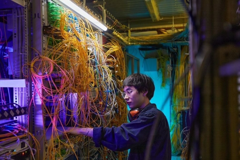 Big data analyst looking at messed several wires 